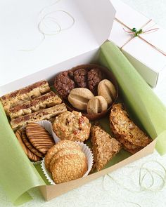 a box filled with different types of cookies and muffins on top of a table