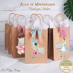 four small bags with alice in wonderland stickers on them, one is brown and the other is pink