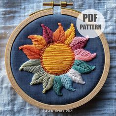 an embroidered sunflower on a blue background with text overlay that reads, free pattern