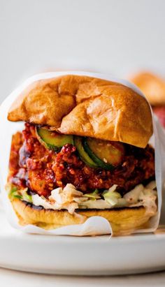 a sandwich with meat and vegetables on a white plate