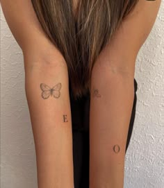 two girls with matching tattoos on their arms, one has a butterfly and the other has a moon