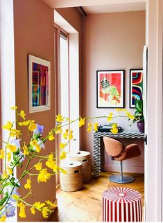 a room with yellow flowers and pictures on the wall