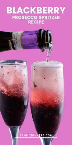 a bottle of booze being poured into two wine glasses with ice and sprinkles