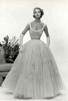 a black and white photo of a woman in a dress