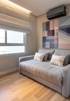 a couch sitting in front of a window next to a wooden floor