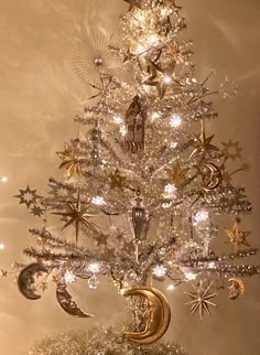 a silver christmas tree with stars and moon decorations