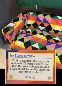 a bed with a colorful quilt on it and a sign in front of it that says, in - store review when i walked into the show and said, i want to