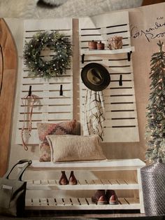 an open book with christmas decorations on the wall and a hat hanging from it's side