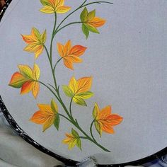 a painted plate with yellow and orange flowers on it