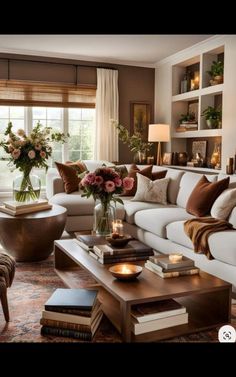 a living room filled with lots of furniture and flowers on top of a coffee table