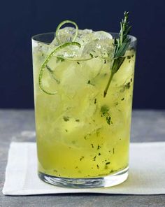 a close up of a drink in a glass with ice and garnishes