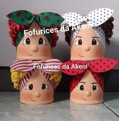 three clay dolls with hair and bows on their heads are sitting next to each other