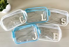 four clear plastic containers with letters on them