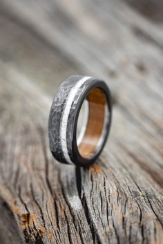 a wooden and metal ring sitting on top of a piece of wood