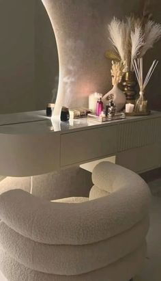 a white chair sitting in front of a mirror next to a table with candles on it