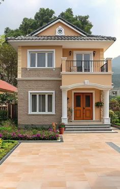 a house that is in the middle of some plants and flowers on the front lawn