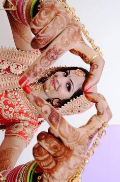 a woman with henna on her face and hands in the shape of two hands