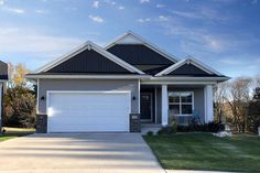 a house with two garages in front of it and grass on the side yard