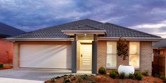 a brick house with two garages in the front yard