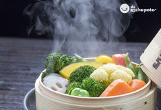 steaming broccoli, cauliflower, carrots and other vegetables in a bowl