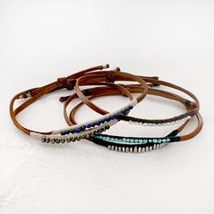 Leather Bracelets would with thread and beaded with pearls, silver, lapis, turquoise or hematite. One size fits all, leather cord is adjustable. These bracelets are waterproof and can be worn at all times. Choose between: Tiny pearls with grey thread.Faceted hematite with cream threadLapis with creamSterling silver beads with dark blue threadTurquoise with dark blue thread Leather Beaded Bracelet, Bead Woven Bracelet, Suede Slides, Bracelet Ideas, Leather Bracelets, Woven Bracelets, Wire Crafts, Home Items, Bead Leather