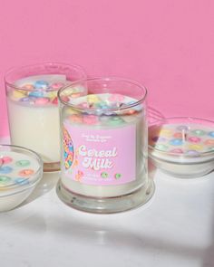 three candles are sitting next to each other on a table with candy in the middle