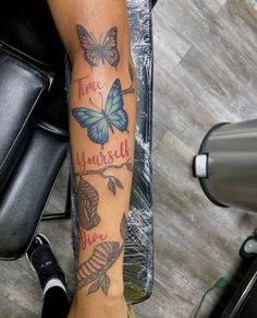 a woman's arm with butterflies and words on it