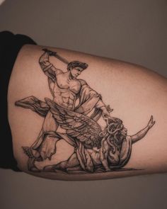 a man with a tattoo on his arm holding a baseball bat next to a statue