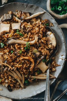 a plate filled with rice and mushrooms on top of a table