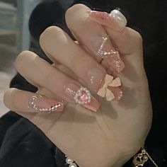 a woman's hand with pink and gold nail polish