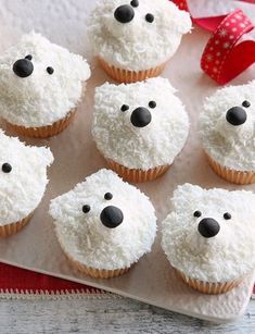 cupcakes decorated with white frosting and black noses are sitting on a tray