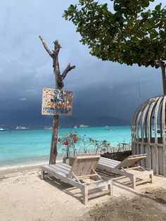 two chairs and a sign on the beach