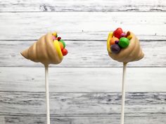 two cake pops with candy and candies on them sitting on top of each other