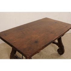 an old wooden table with wheels on the legs