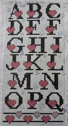 a cross - stitch pattern with hearts and letters in the middle, on a sheet of paper