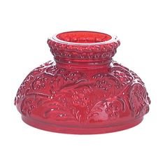 a red glass vase sitting on top of a table