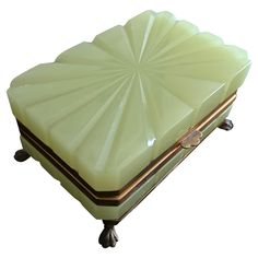 an antique green box with gold trimmings on the top and bottom, sitting on wheels