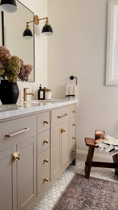 a bathroom with an area rug, sink and mirror on the wall next to it