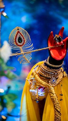 an elaborately decorated headdress is displayed in front of a bright blue background