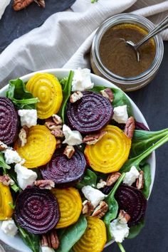 a salad with beets, goat cheese and pecans on top is shown in a bowl