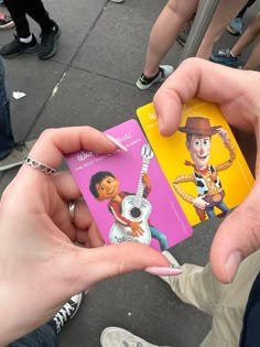 a person holding up a card with an image of toy story characters on it in their hands