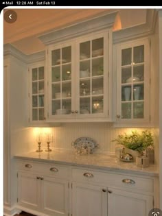 a kitchen with white cabinets and wooden floors