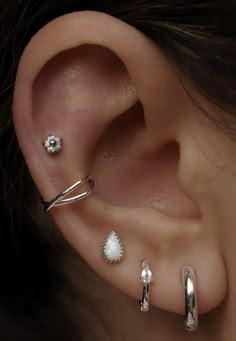 an ear with three different types of piercings on it's sides and one is in the middle