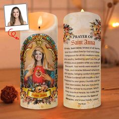 a candle with an image of the virgin mary on it and a prayer card next to it