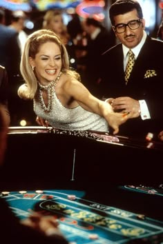 a woman in a white dress standing next to a casino roule