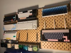 there are many keyboards and mouses on the pegboard in front of each other