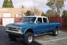 a blue and white truck parked in a parking lot