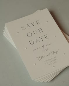 wedding save the date cards on top of each other, with pearls and sparkles