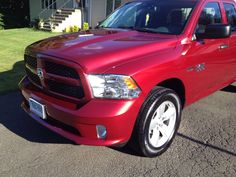 a red ram truck parked in front of a house on the side of the road