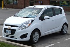 a small white car parked in front of a store